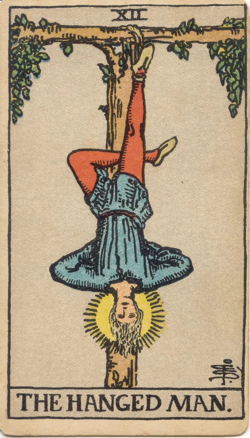 O Enforcado no tarot Rider-Waite-Smith: homem suspenso por um pé, com a outra perna dobrada e uma auréola em torno da cabeça.